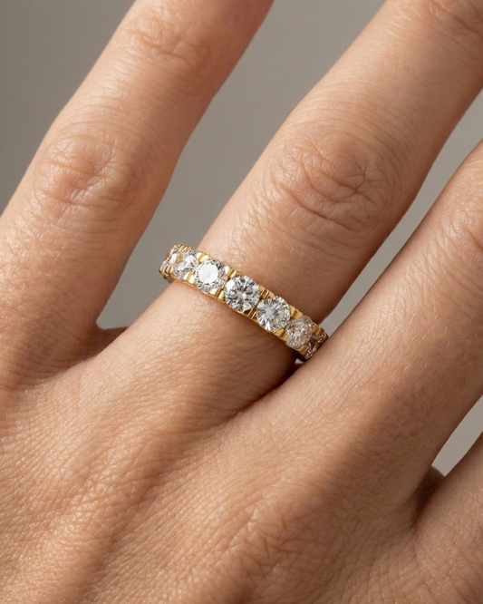 A magnificent 14k yellow gold eternity band featuring a continuous circle of 4.0 total carats of brilliant round-cut lab-grown diamonds on hand.
