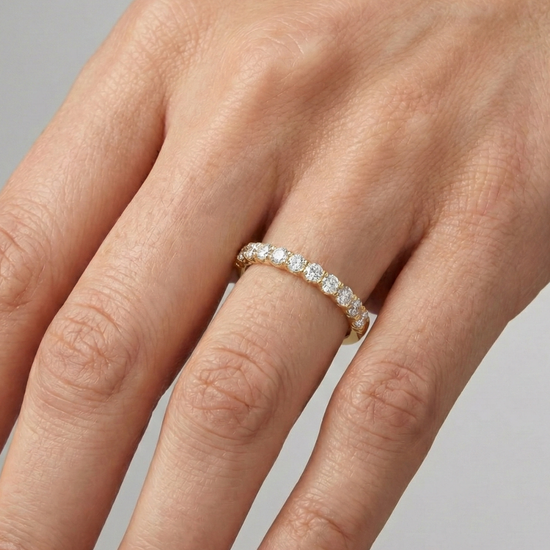 A delicate 14k yellow gold wedding band featuring 0.33 total carats of round-cut lab-grown diamonds in a classic half eternity setting on hand.