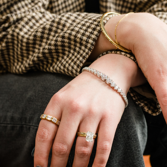 Yellow gold Amorati Skyline Diamond Mosaic Ring worn on a model's index finger, styled with a diamond engagement ring and a diamond tennis bracelet.