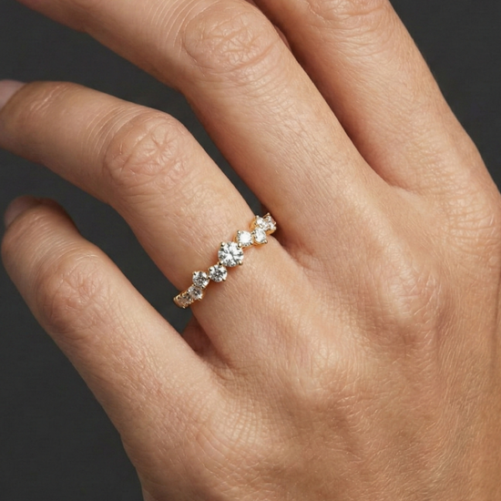 A top-down view of a 14K yellow gold ring with a five-stone cluster of alternating marquise and round diamonds on hand.