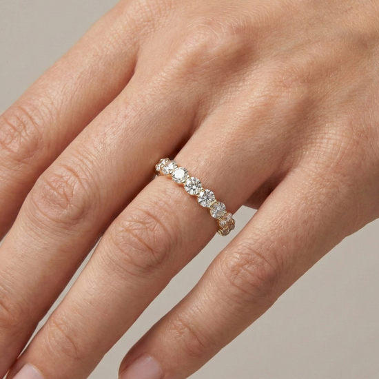 On hand luxurious 14k yellow gold 2/3 eternity wedding band featuring 1.5 total carats of graduated round-cut lab-grown diamonds.