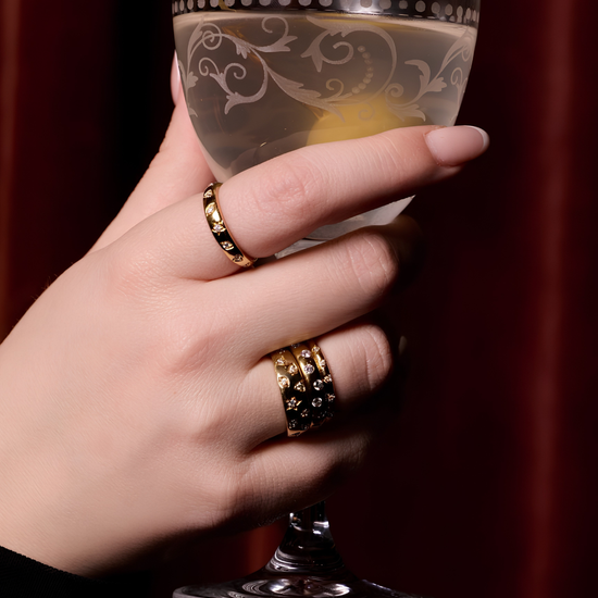 A lifestyle view of A high-polish 14k yellow gold dome ring by Amorati featuring scattered star and geometric insets with shimmering round-cut diamonds. Amorati’s signature F O U R T E E N T H Collection.
