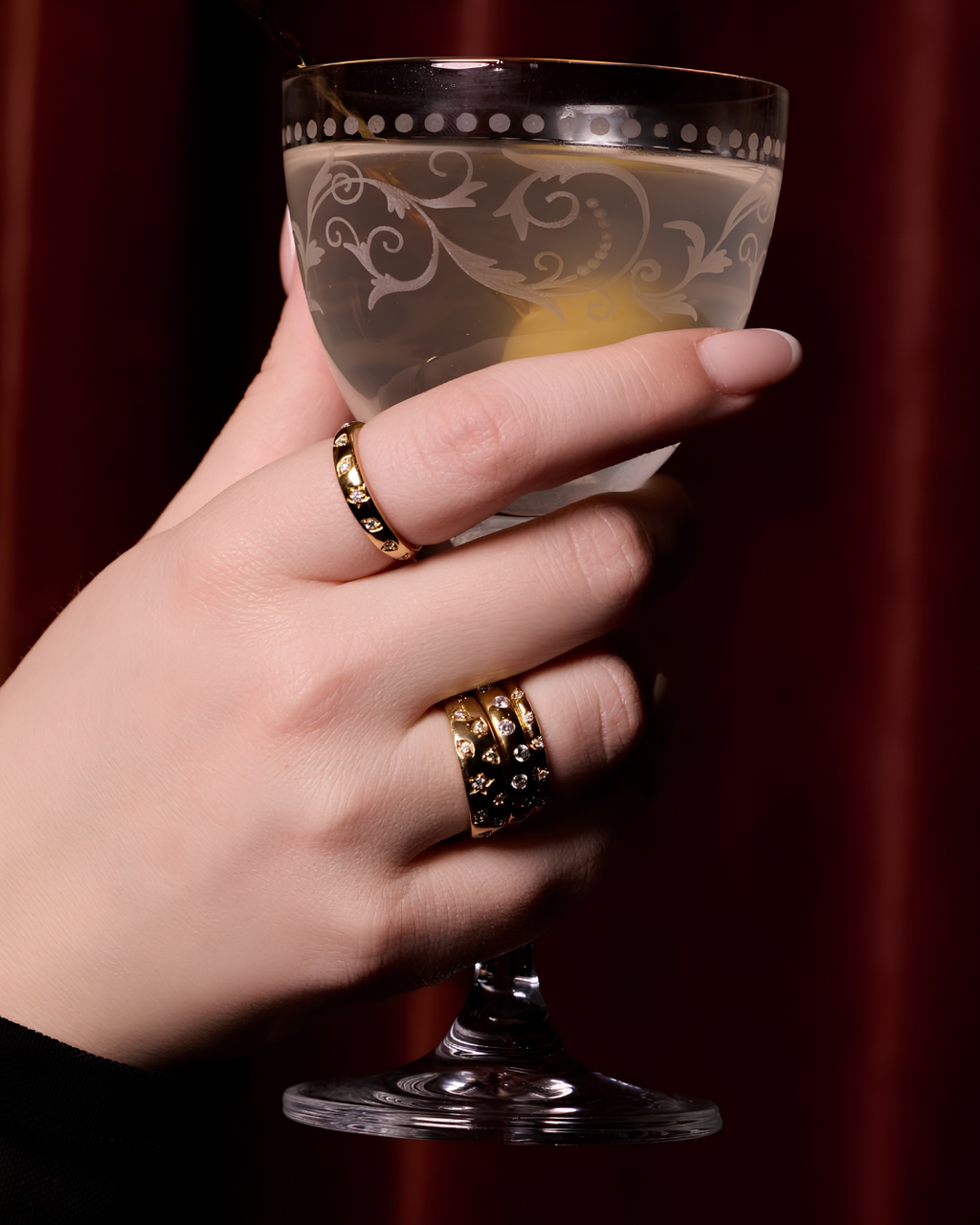 A lifestyle view of A high-polish 14k yellow gold dome ring by Amorati featuring scattered star and geometric insets with shimmering round-cut diamonds. Amorati’s signature F O U R T E E N T H Collection.