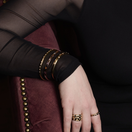 A slim 14k yellow gold stackable ring by Amorati featuring delicate star-shaped insets with shimmering round lab-grown diamonds, elegantly displayed on a model’s hand. Amorati’s signature F O U R T E E N T H Collection.