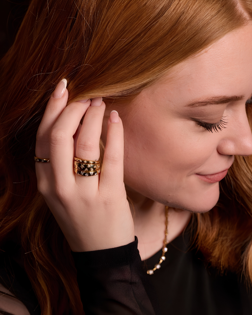 A high-polish, slender 14K yellow gold stackable ring by Amorati, delicately detailed with petite star-shaped insets, each set with a shimmering round lab-grown diamond, elegantly displayed on a model’s hand. Amorati’s signature F O U R T E E N T H Collection.