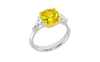 Angled view of a white gold three-stone ring featuring a with 3.50ct IGI Certified Center Yellow Canary Cushion lab grown VS+ E-F elite stone and an additional .66 cttw trillion VS+ E-F side stones for a total of 4.16 cttw of great value and ships insured for free.
