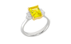 Angled view of a white gold three-stone ring featuring a yellow diamond center with white diamond side stones and a polished band.