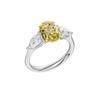 Angled view of a white gold three-stone ring featuring a yellow diamond center and pear-shaped white diamonds with a polished finish.