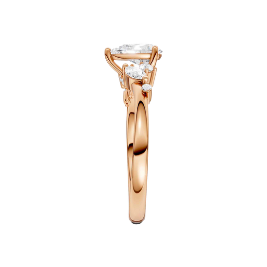 A side-profile view of a 14K rose gold ring, showing the graceful setting of the three gems.