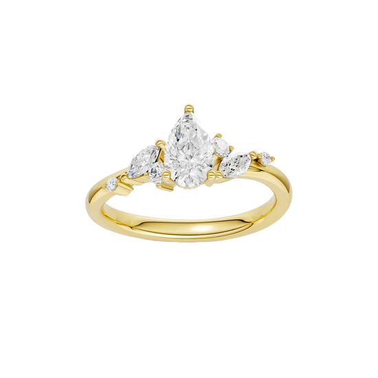 A top-down view of a 14K yellow gold ring with a three-stone cluster of round and pear-shaped gems.