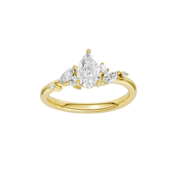 A top-down view of a 14K yellow gold ring with a three-stone cluster of round and pear-shaped gems.