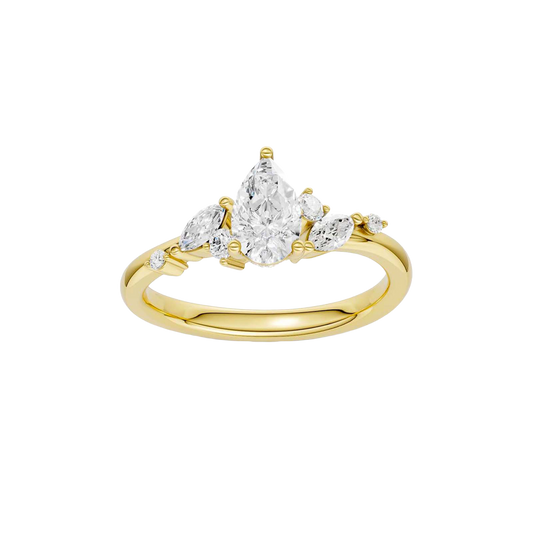 A top-down view of a 14K yellow gold ring with a three-stone cluster of round and pear-shaped gems.