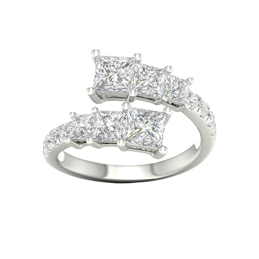 A top-down view of a 14K white gold ring with an asymmetrical cluster of princess-cut and baguette diamonds.