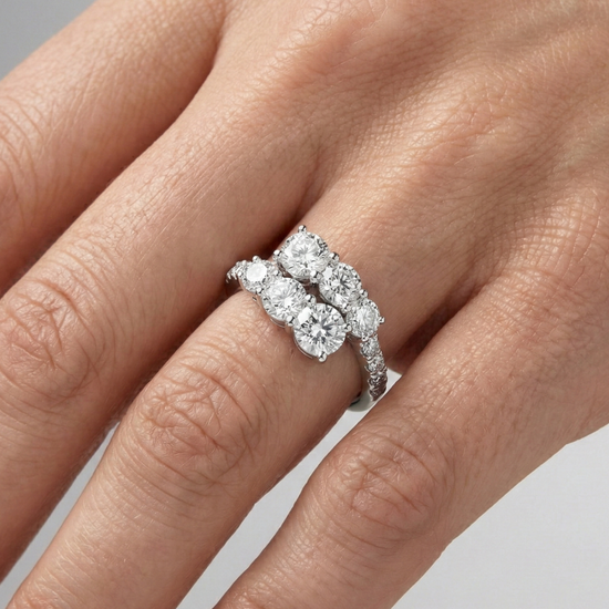 Yellow gold diamond ring resting on black marble, featuring multiple round brilliant-cut diamonds arranged in a modern layered design with pavé diamonds on hand.