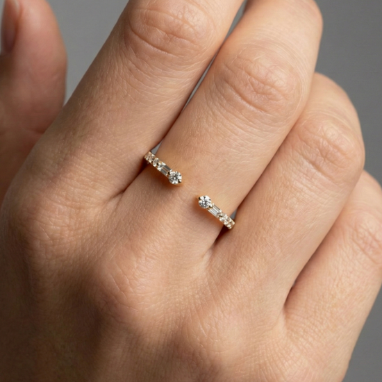 Amorati Diamonds Embrace Cluster Ring, a top-down view of a 10K yellow gold bypass ring with a three-diamond cluster at each end on hand.