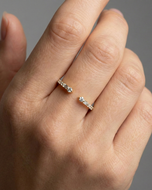 Amorati Diamonds Embrace Cluster Ring, a top-down view of a 10K yellow gold bypass ring with a three-diamond cluster at each end on hand.