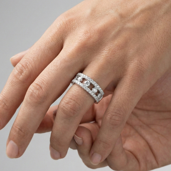A top-down view of a 14K white gold wide band ring with three rows of pavé diamonds on hand.