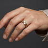 A top-down view of a 14K white gold bypass ring with a central cluster of three horizontal baguette diamonds on hand.